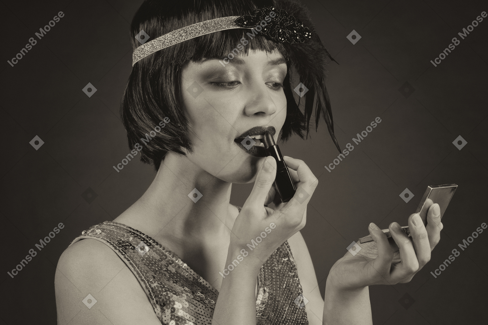 Glamorous flapper applying a lipstick and looking at hand mirror