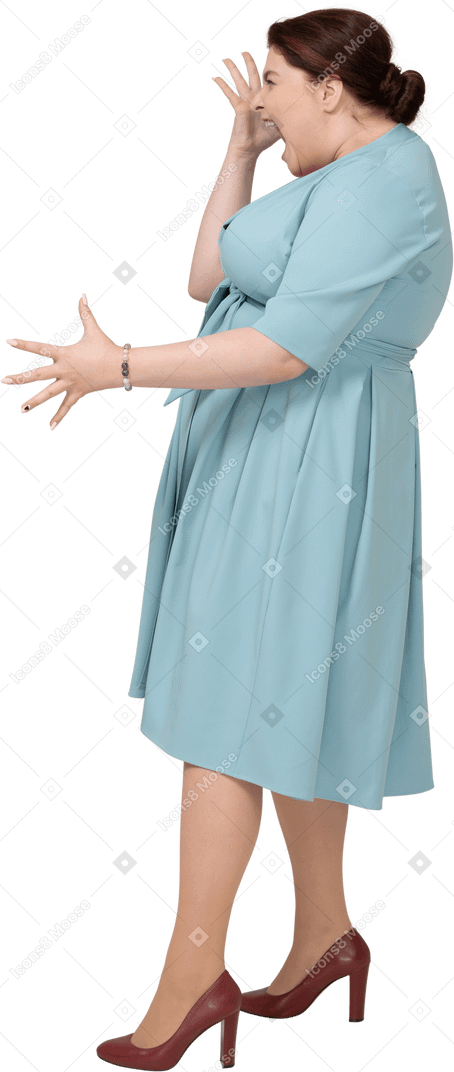 Женщина в синем платье жестикулирует, вид сбоку