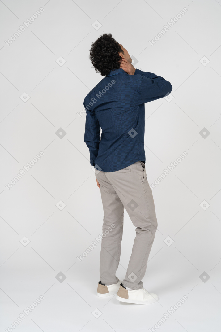 Vista laterale di un uomo in abiti casual che soffre di dolore al collo