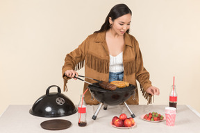 Jovem mulher asiática fazendo churrasco