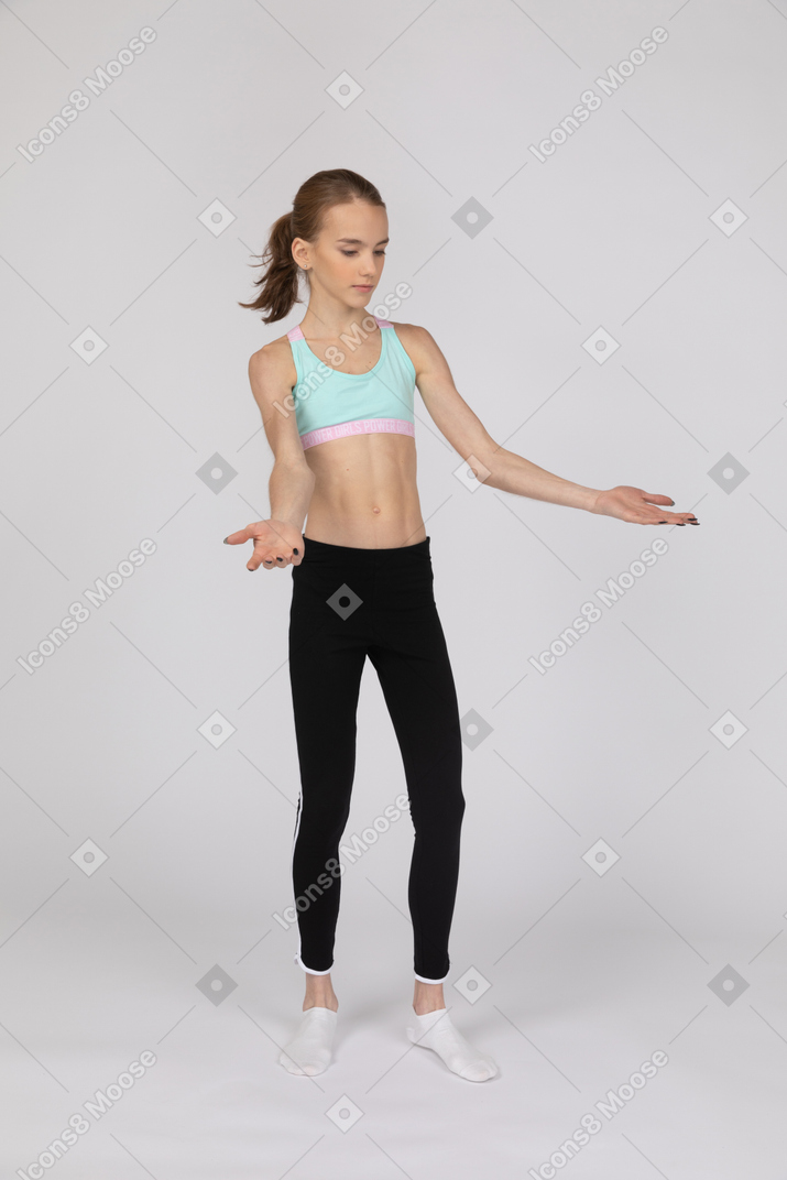 Una adolescente en ropa deportiva extendiendo sus manos.
