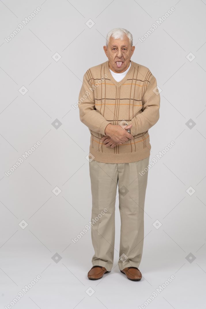 Vista frontale di un uomo anziano in abiti casual che mostra la lingua