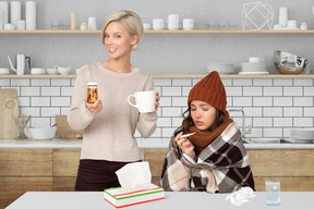 Woman holding cup of tea and pills for a sick friend