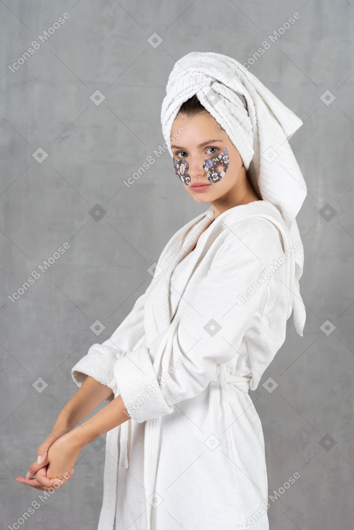 Side view of a woman in bathrobe with her hands together