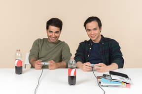 Interracial friends sitting at the table and playing video game