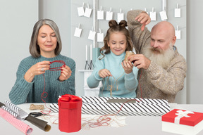 Grandparents getting ready for christmas together with their granddaughter