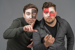 Front view of two male football fans watching football