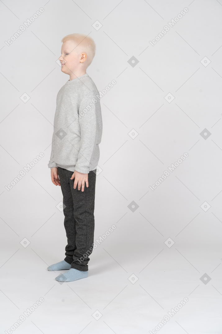 一个小男孩站着不动的四分之三视图