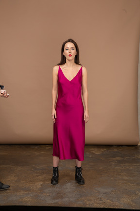 Front view of a young woman in beautiful red dress looking at camera