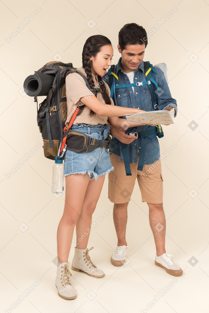 Young interracial couple looking attentively at map