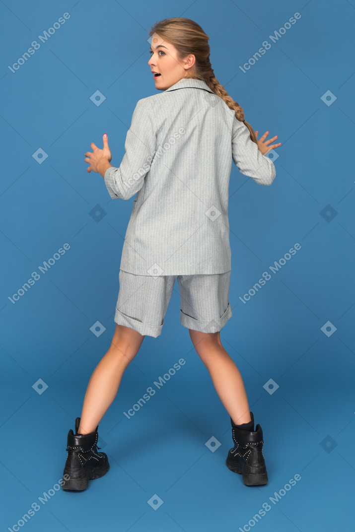 Young woman keeping legs wide apart while dancing
