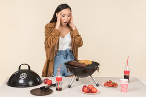 Mujer asiática joven preocupada haciendo una barbacoa