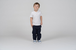 Front view of joyful little boy standing upright