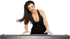 Vista frontal de uma jovem satisfeita em um vestido preto tocando piano enquanto sorri