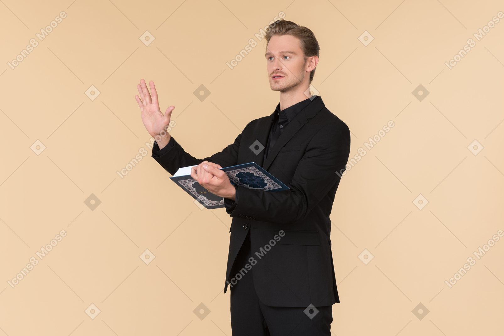 A white man in a fully black suit holding the quran