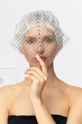 Woman holding a transparent grid in front of her face
