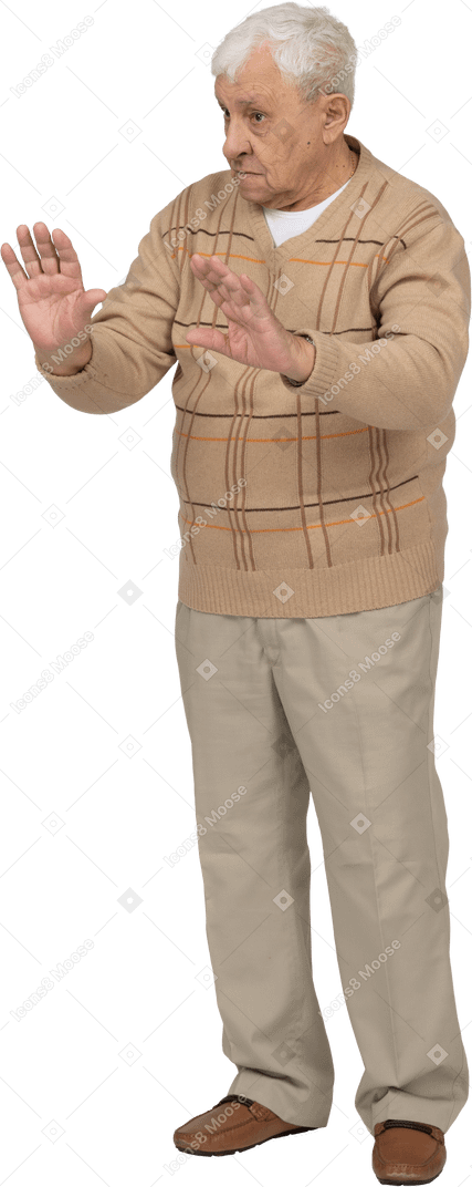 Vista frontal de un anciano con ropa informal que muestra un gesto de parada