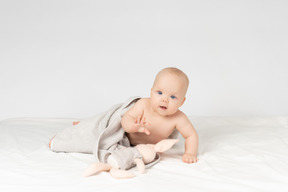 Baby girl covered in towel and holding a toy