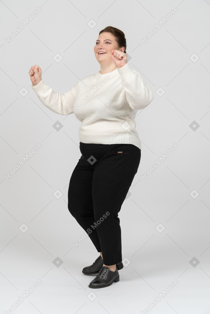 Веселая пухлая женщина в повседневной одежде танцует