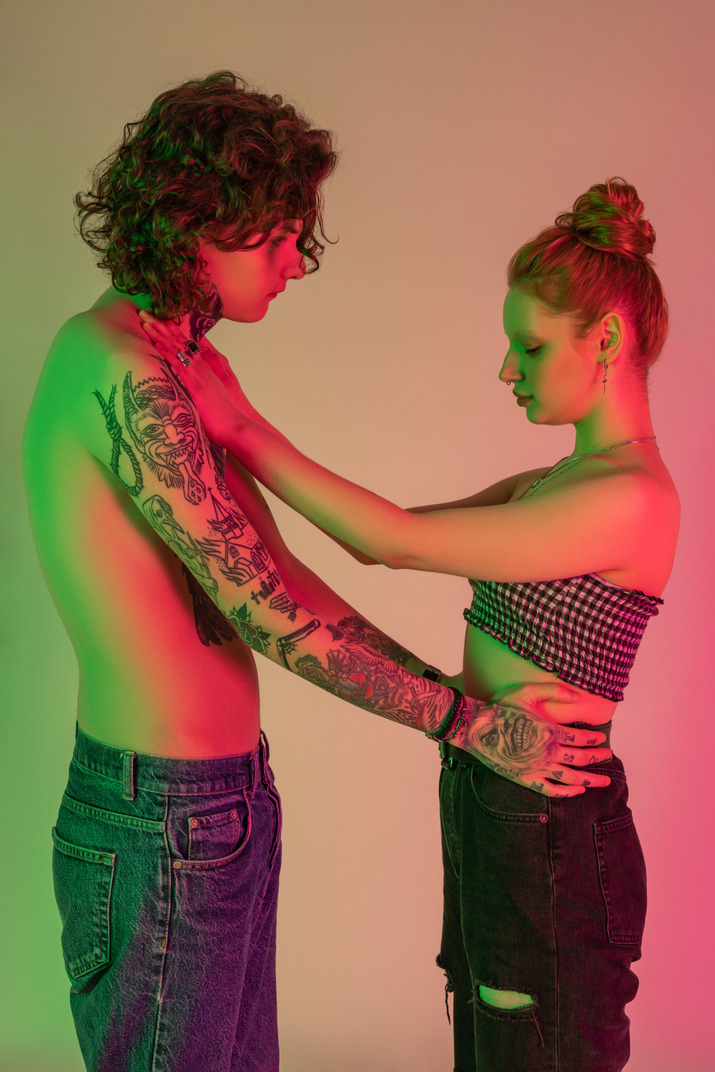 Teen couple in casual clothes in neon light