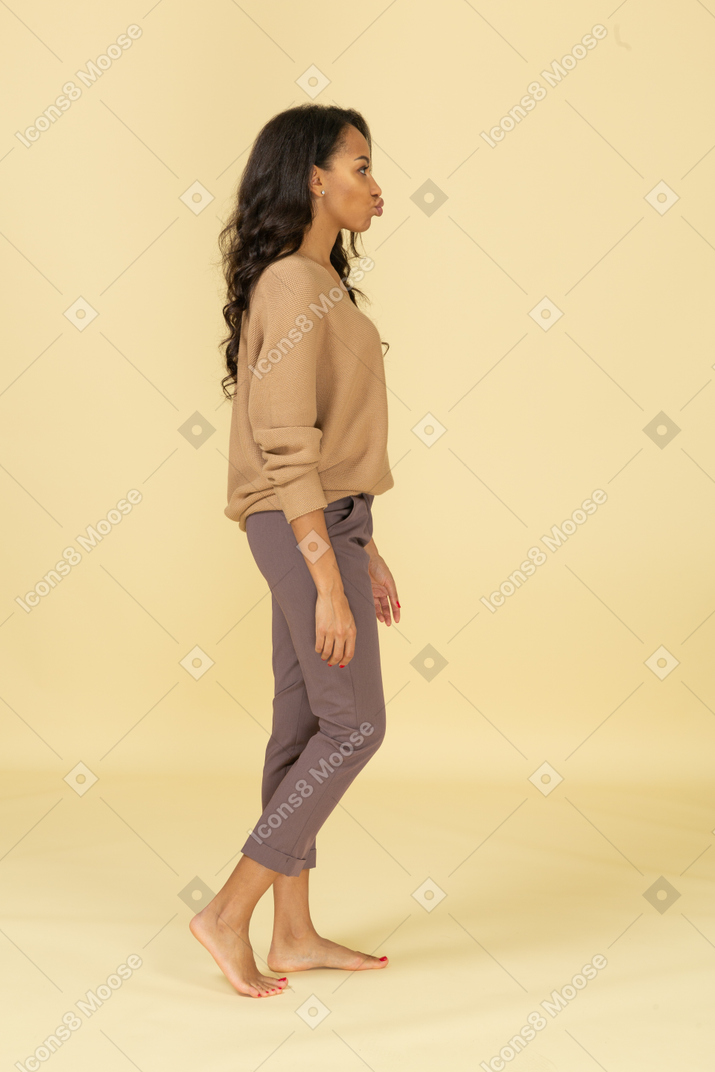 Side view of a young female in casual clothes pouting