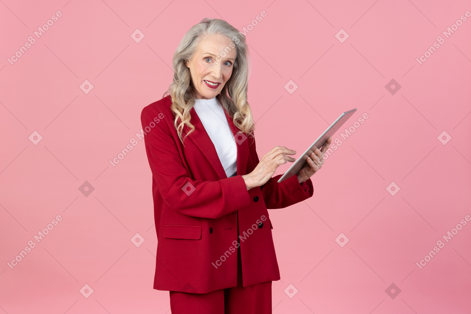 Donna invecchiata dell'ufficio che per mezzo di un ridurre in pani digitale