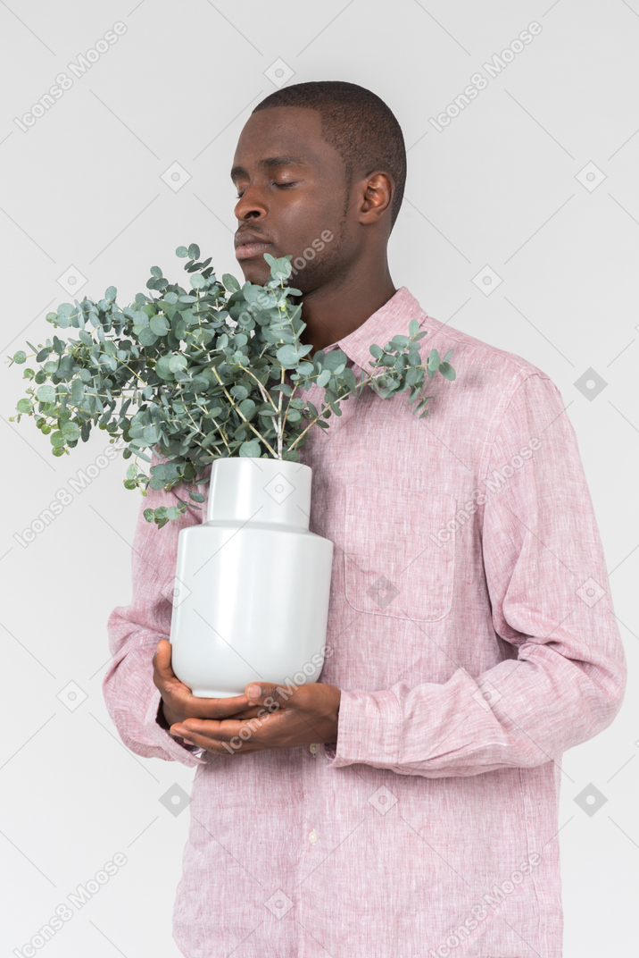 Good looking young man holding a flower pot