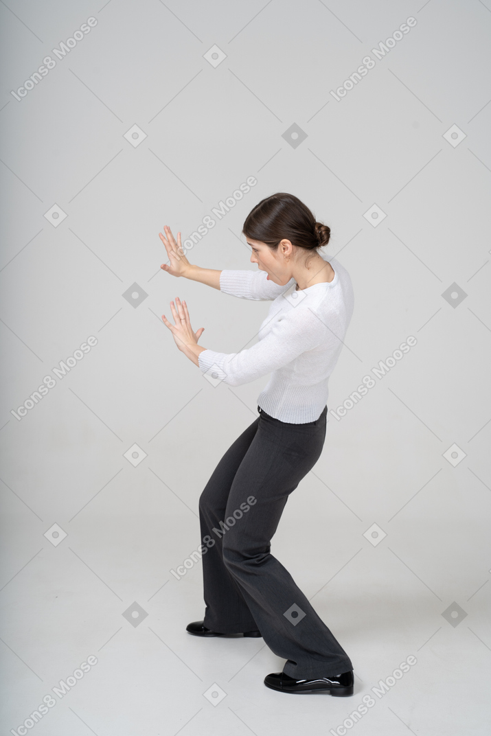 Vista lateral de una mujer joven que muestra un gesto de parada