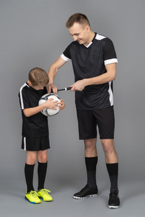 De cuerpo entero de un joven entrenando a un niño