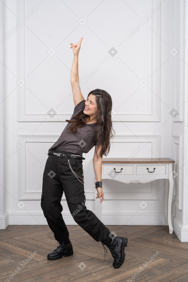 Three-quarter view of a female rocker raising her hand