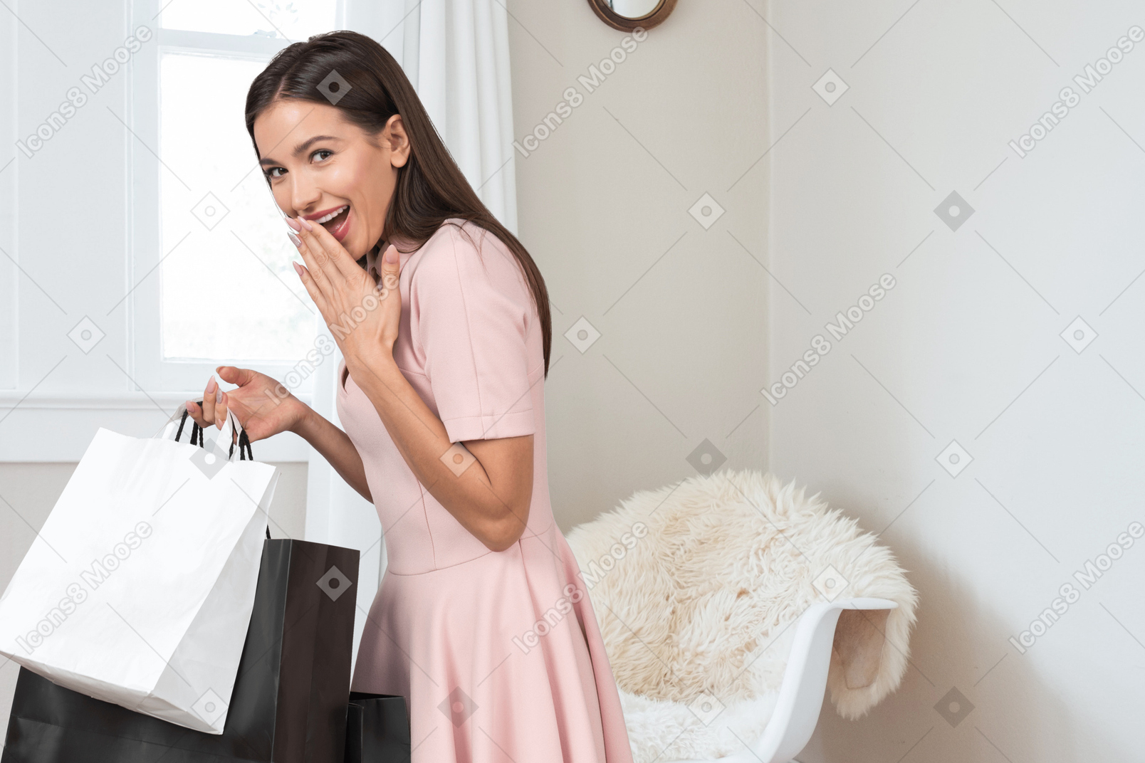 A woman in a pink dress holding shopping bags