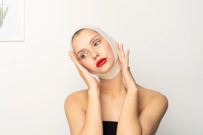 Young woman with bandaged head touching her face