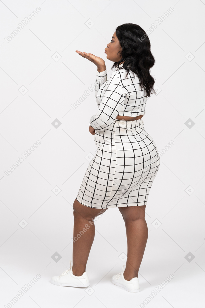 Side view of a beautiful woman blowing a kiss