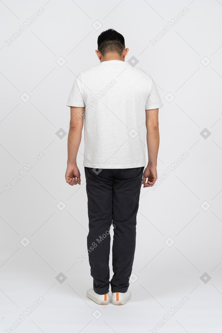 Rear view of a man in casual clothes looking down