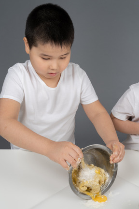 Un niño pequeño preparando una masa