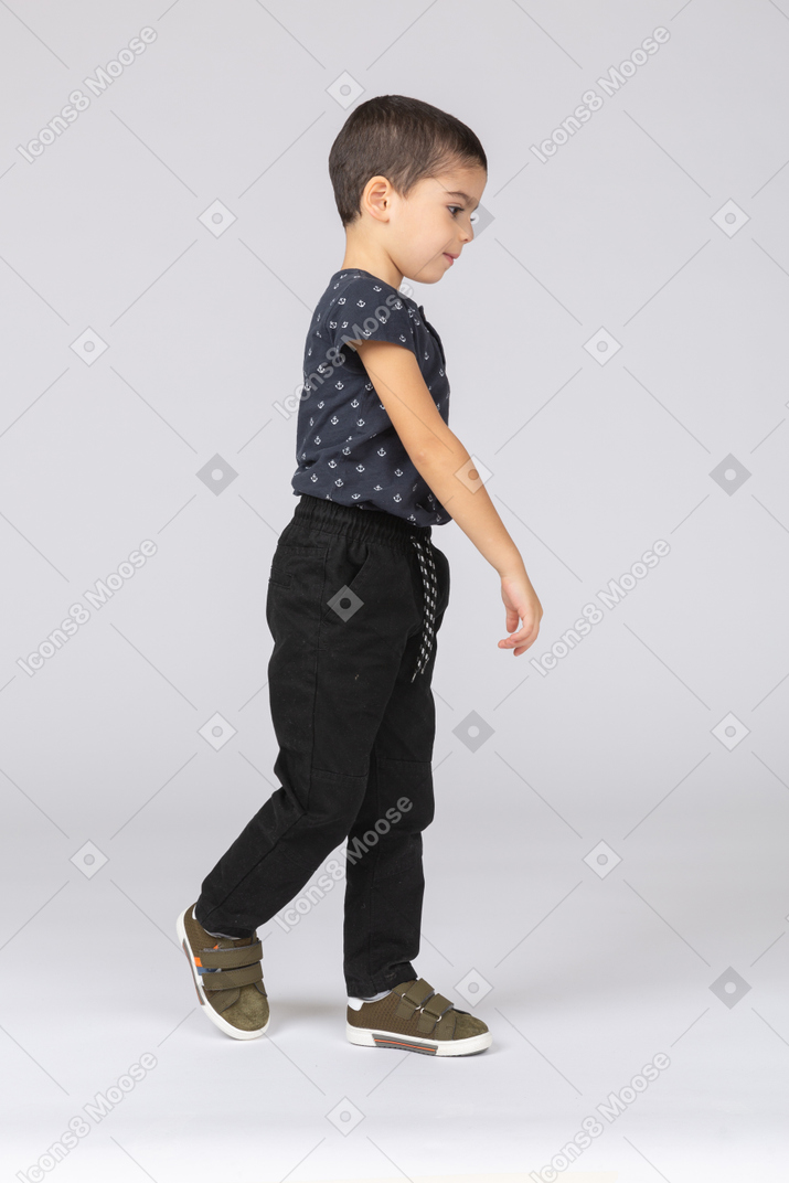 一个穿休闲服的男孩走路的侧视图