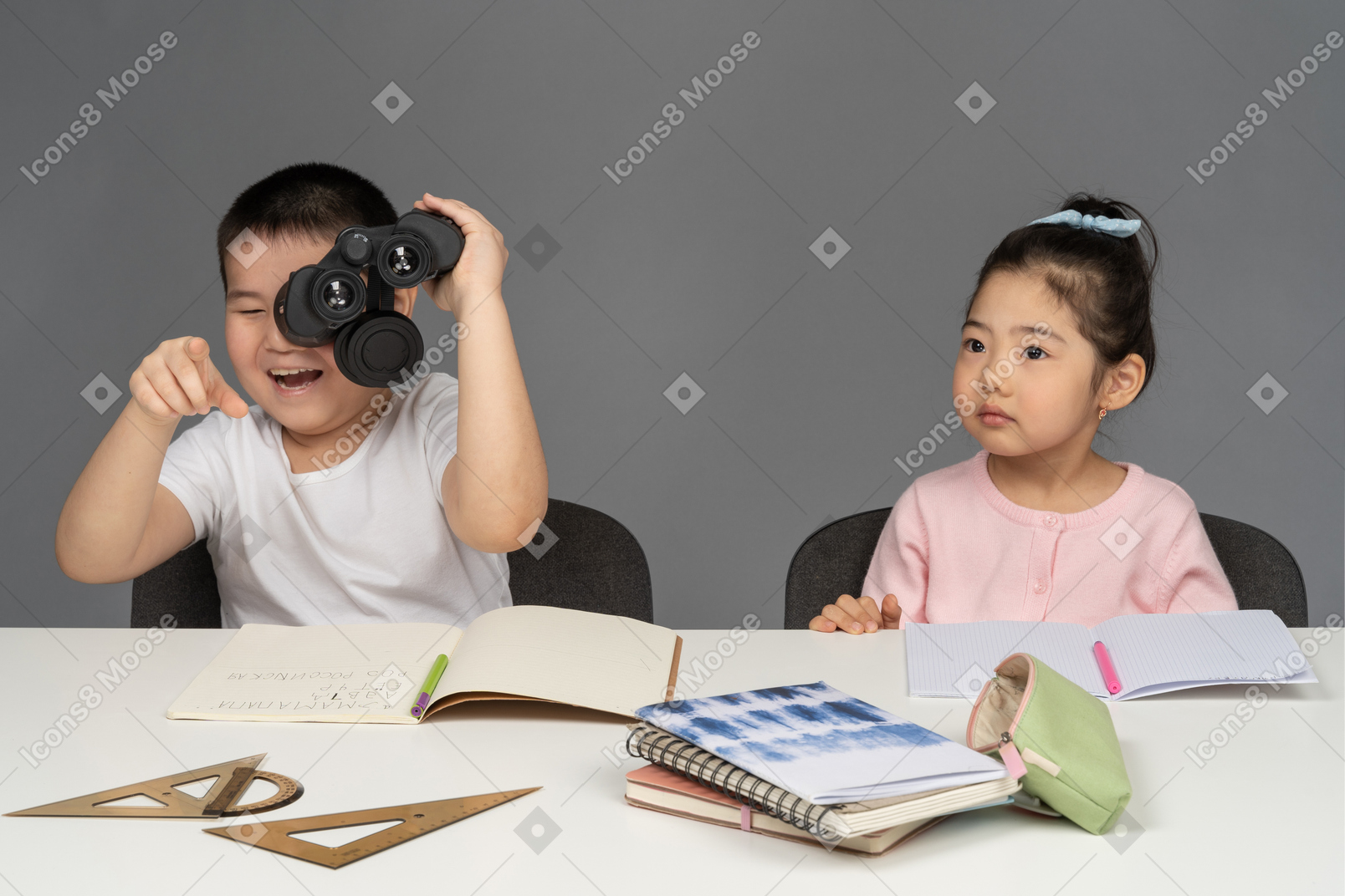 笑着的男孩看着小女孩旁边的双筒望远镜