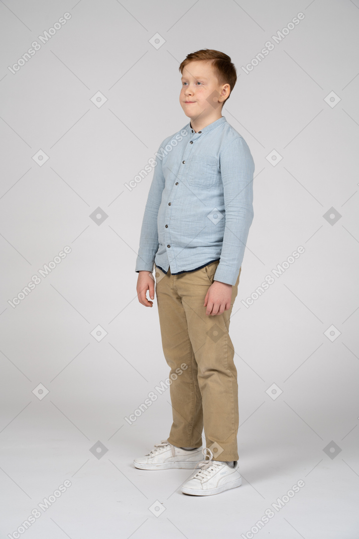 Прекрасный мальчик в повседневной одежде стоит на месте