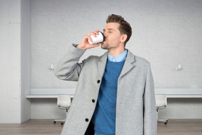 A man drinking a coffee in an office