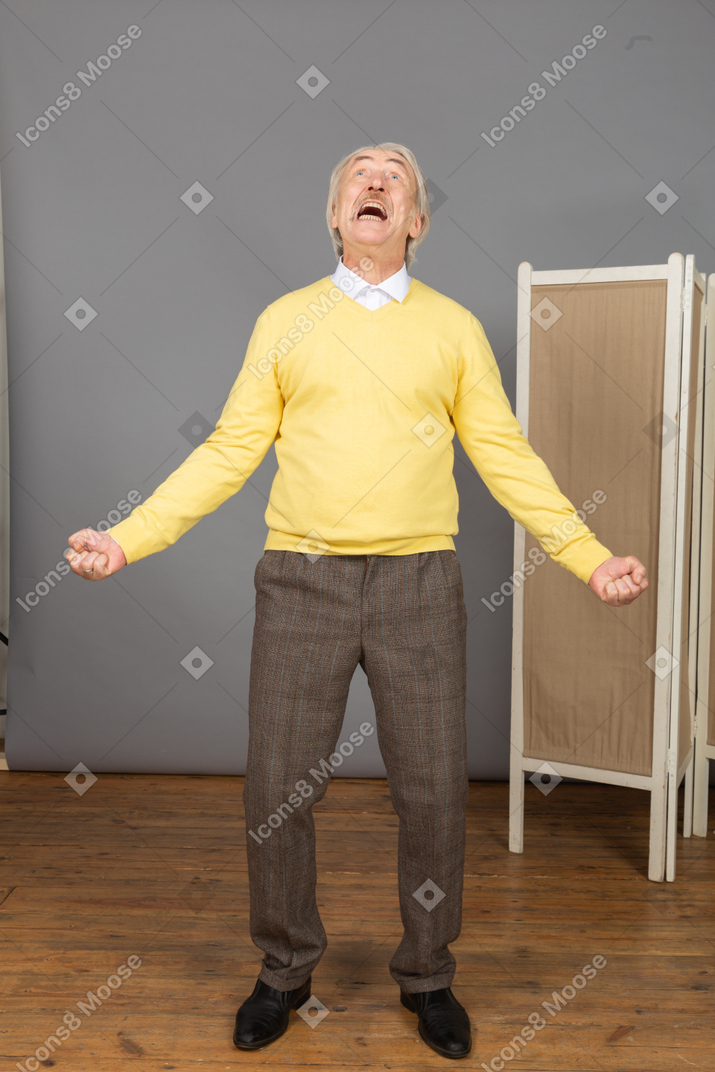 Front view of a screaming old man outspreading hands while looking up