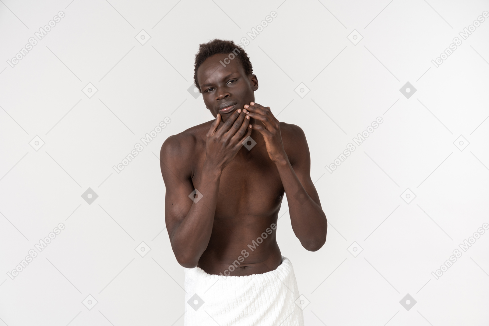 Un jeune homme noir avec une serviette de bain blanche autour de la taille faisant sa routine du matin