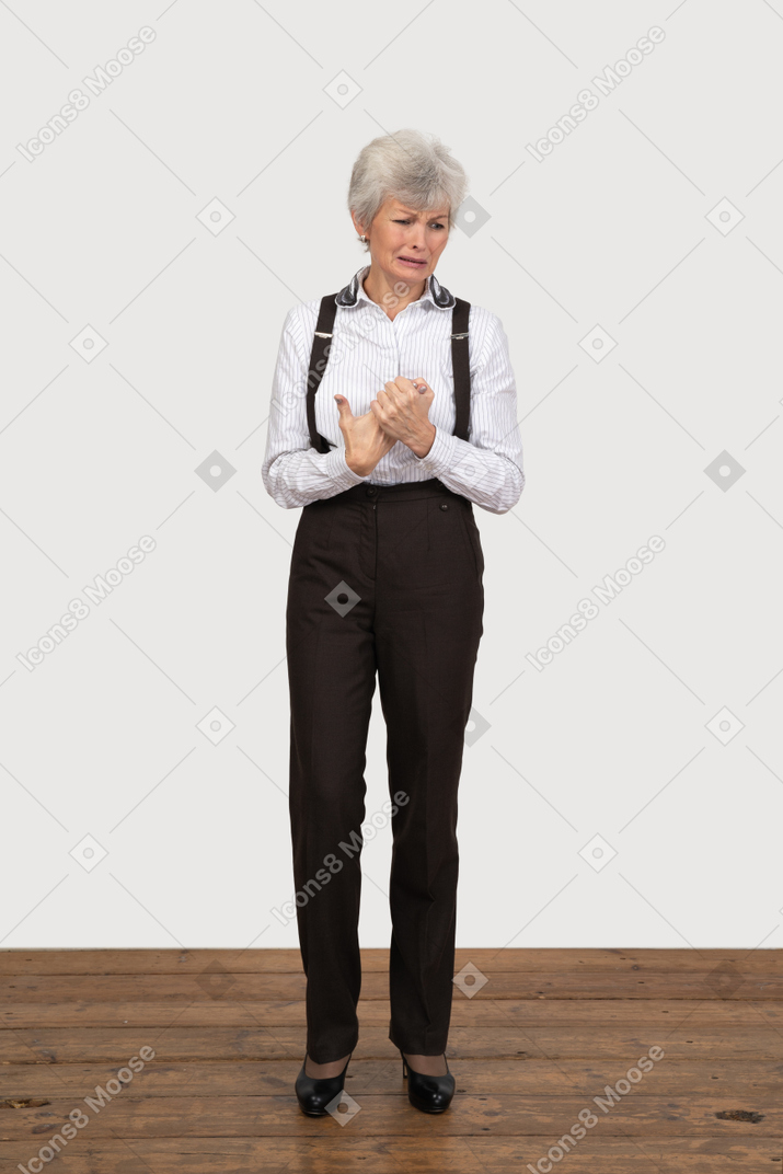 哭泣的老太太在办公室服装，手牵着手的前视图