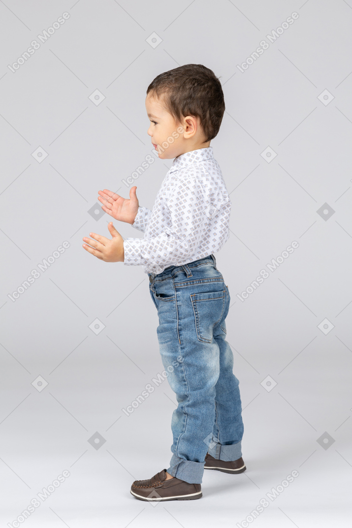 Side view of little boy gesturing