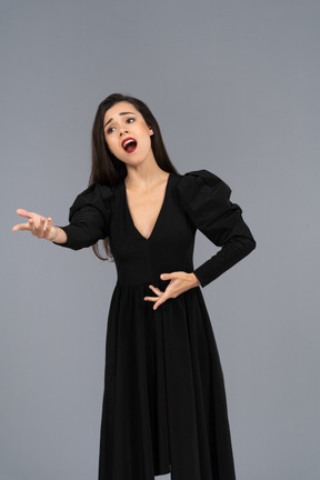 Vista frontal de una cantante de ópera gesticulando en vestido negro