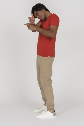 Young man pointing with two finger guns