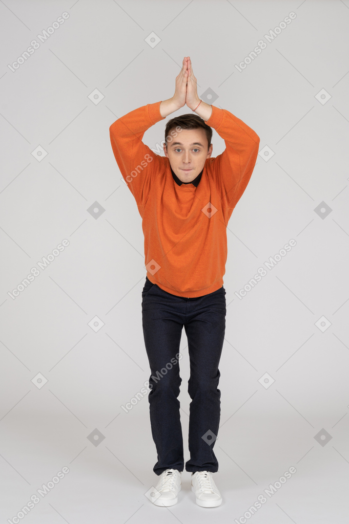 Jeune homme en sweat-shirt orange posant