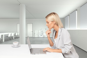 A woman sitting at a table using a laptop computer