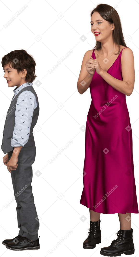 Женщина держит ее за руку и мальчик стоит рядом с ней
