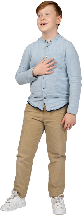 Front view of a cute boy posing with hand on chest