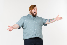 A plump man standing with his hands on his hips and laughing